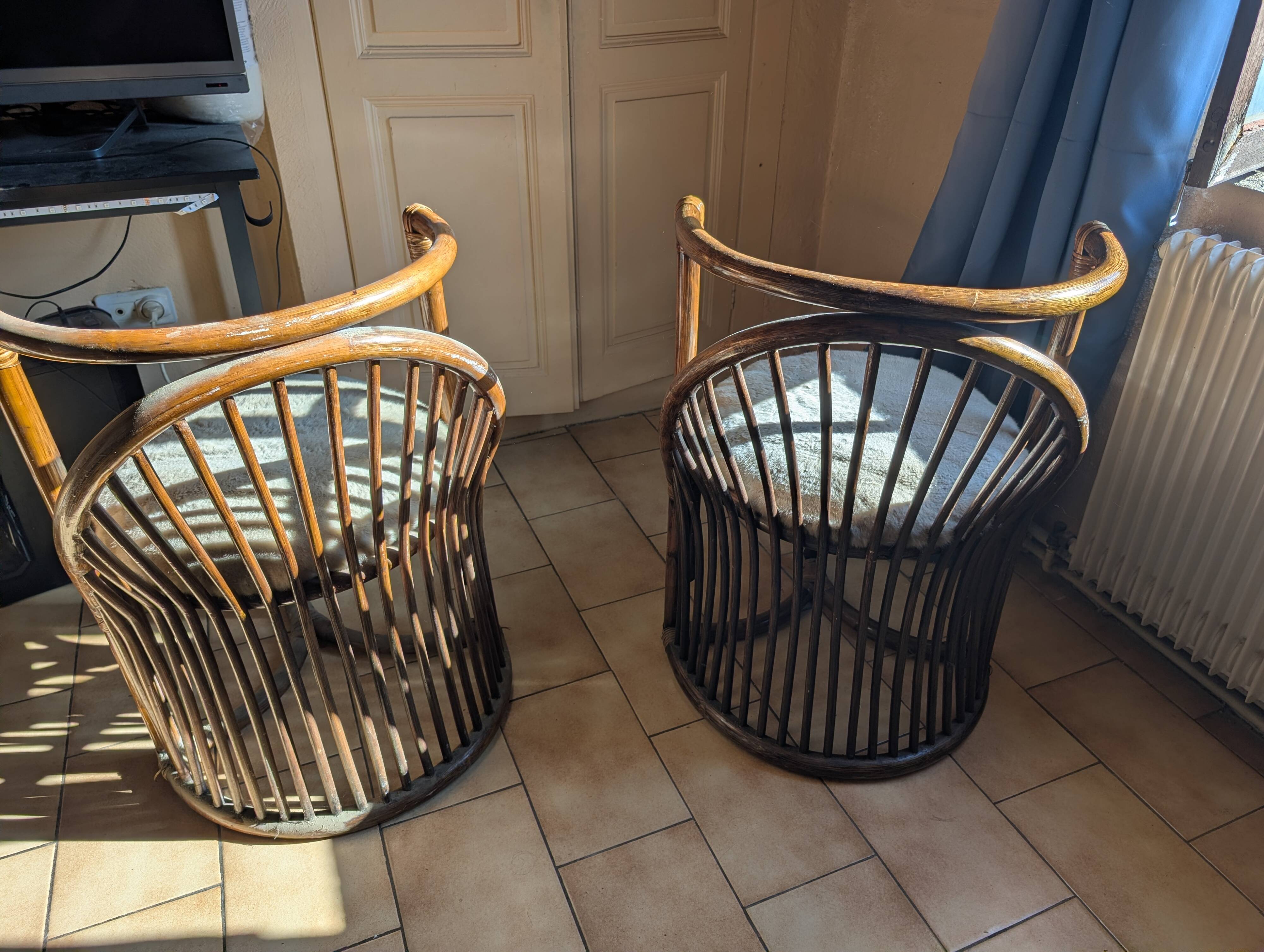 Pair of vintage rattan armchairs with soft fabric seats