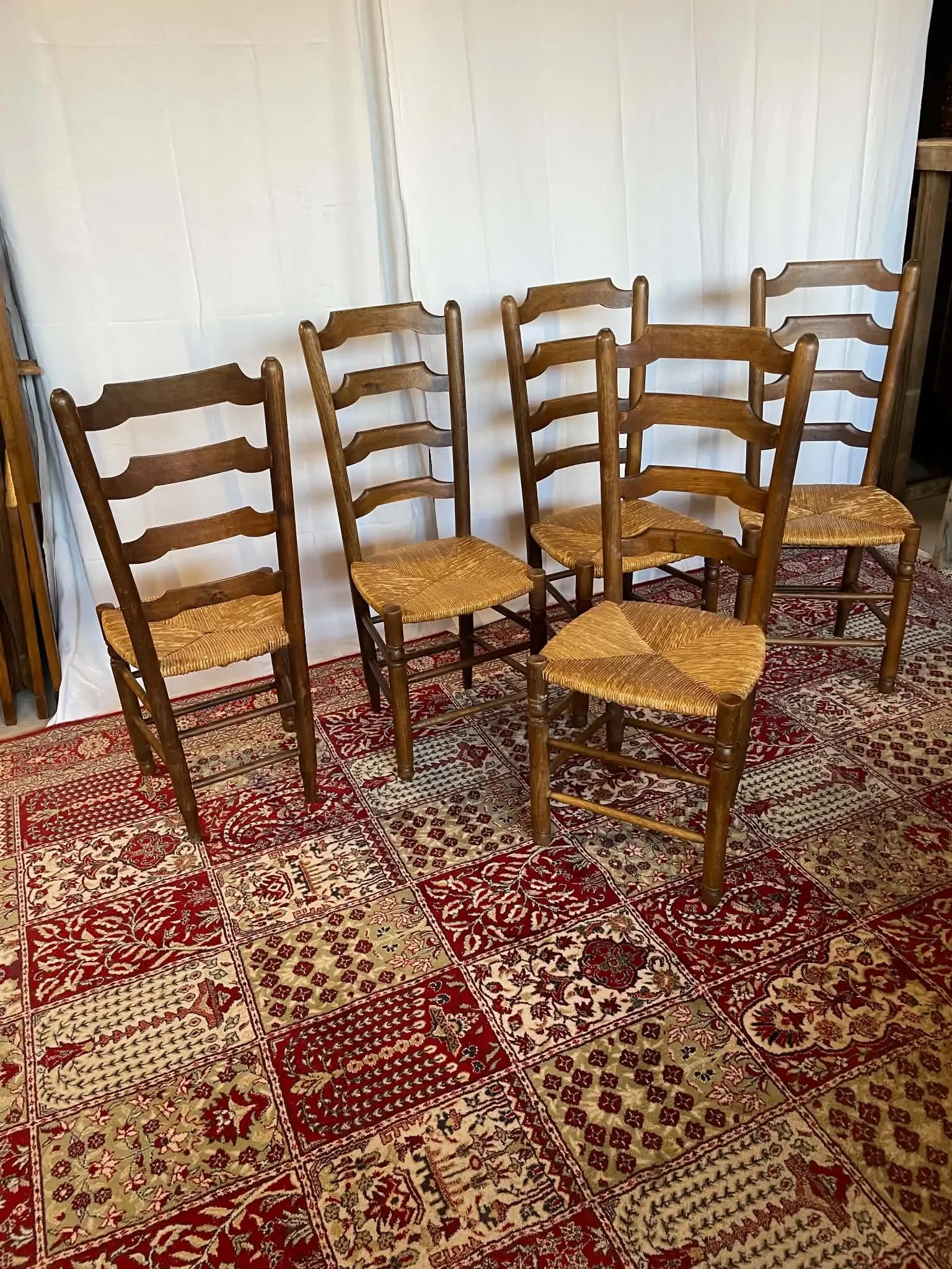 Set of 5 antique solid oak chairs with straw seats.