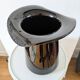 Large black glass vase topped with a 70s hat