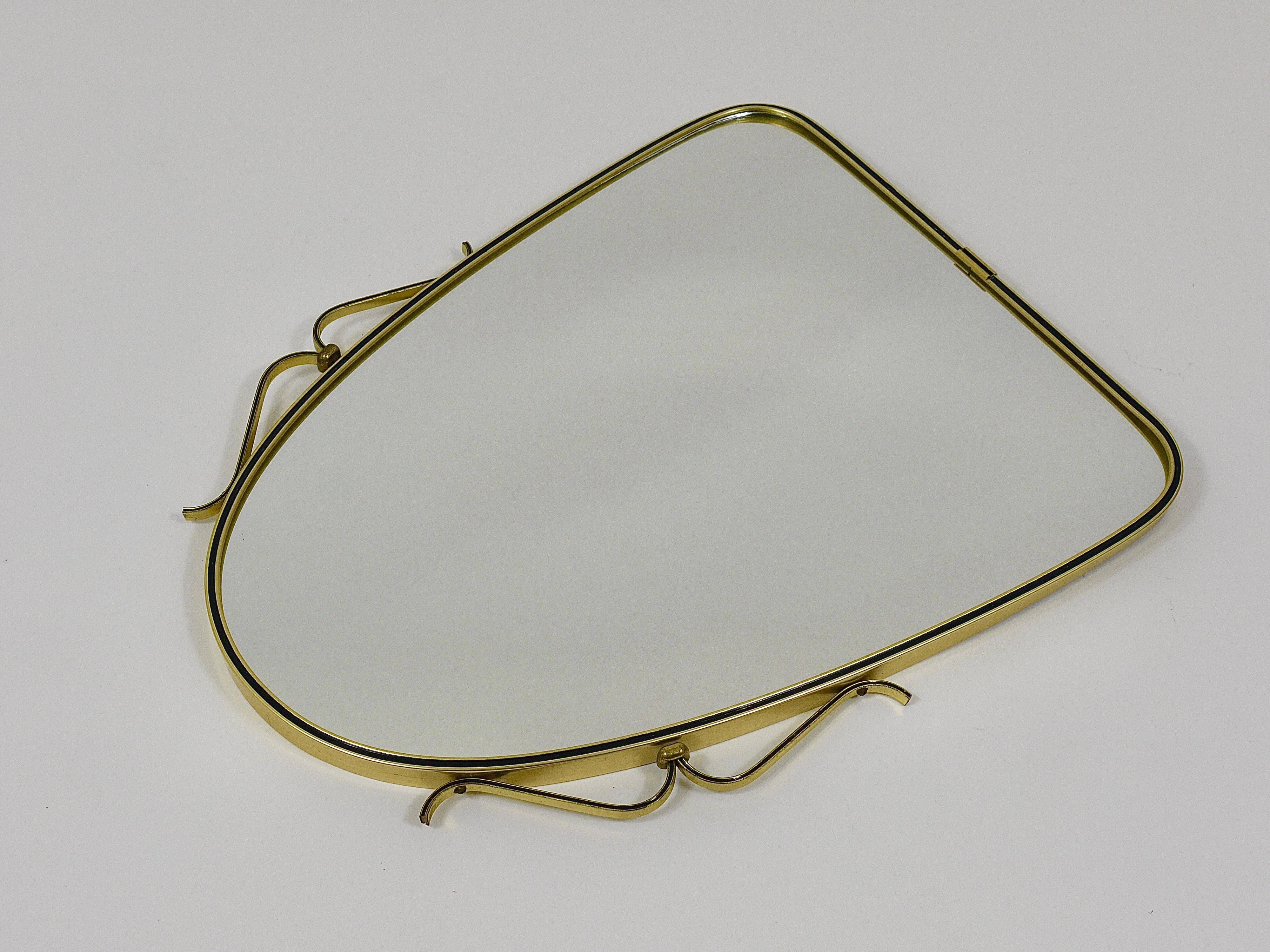 Elegant wall mirror in brass and black from the mid-century, Italy, 1950s.
