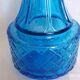 Turquoise glass carafe bottle with a stopper.