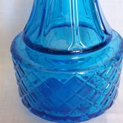 Turquoise glass carafe bottle with a stopper.