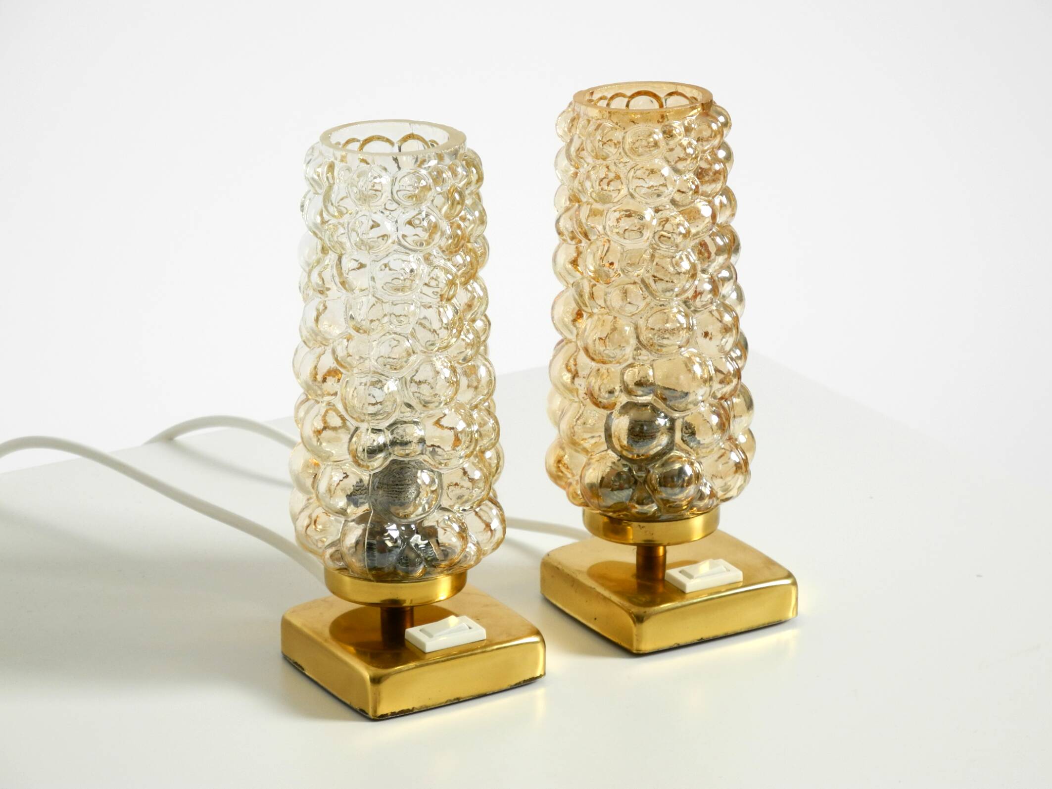 Deux lampes de chevet en laiton rares des années 1960 avec des abat-jours en verre bullé doré.