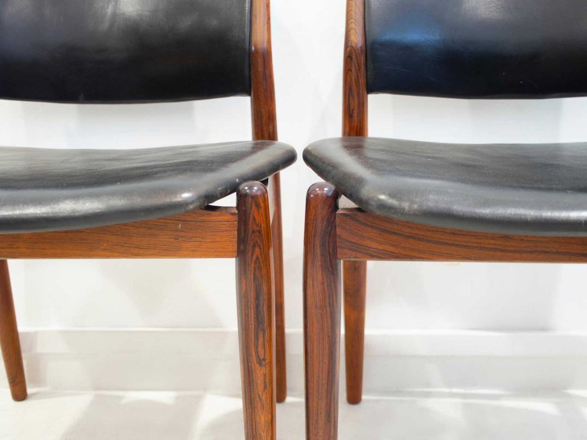 Set of four Arne Vodder chairs in hardwood and black leather.