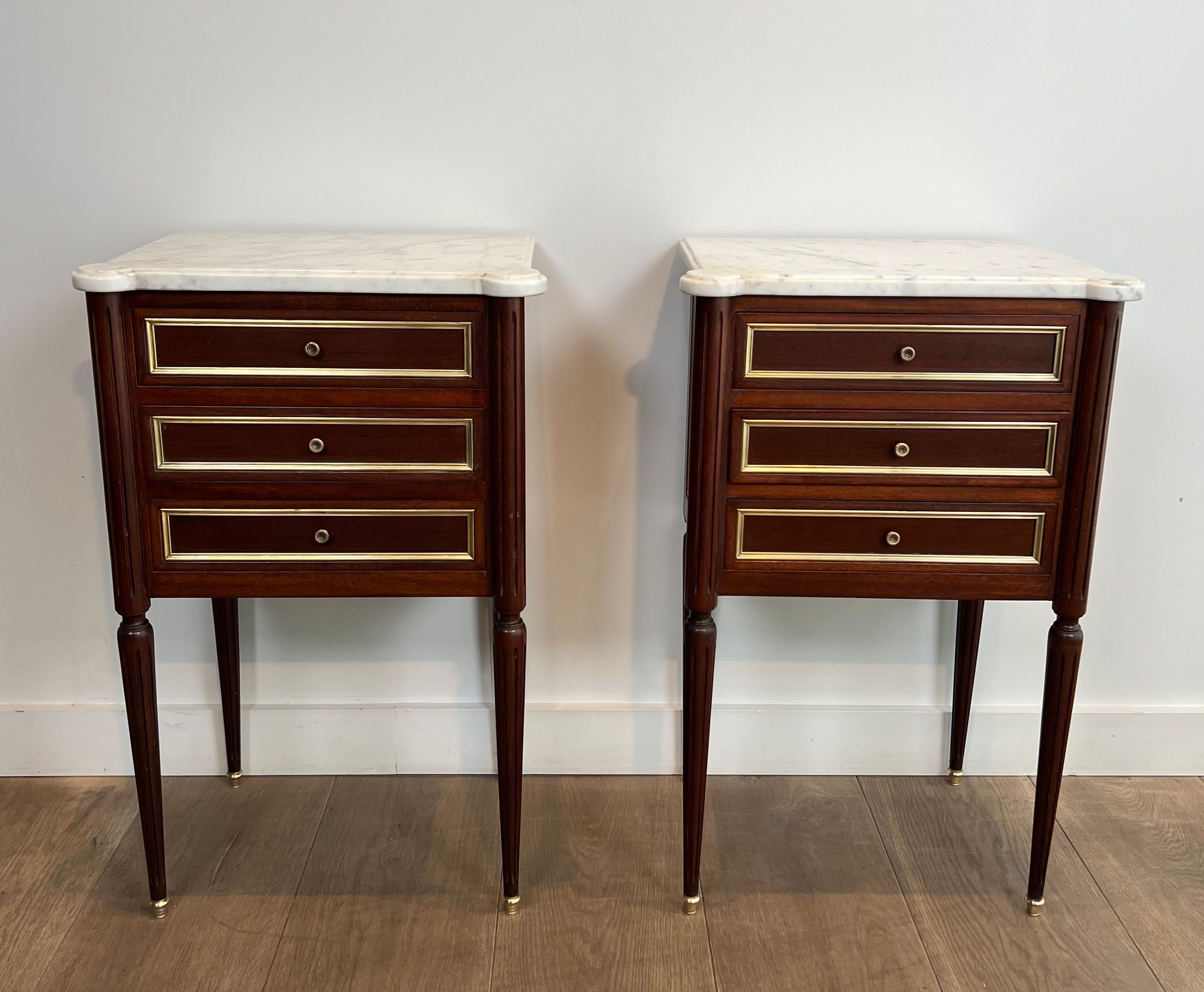 Pair of mahogany and brass side tables or bedside tables with Carrara marble tops.