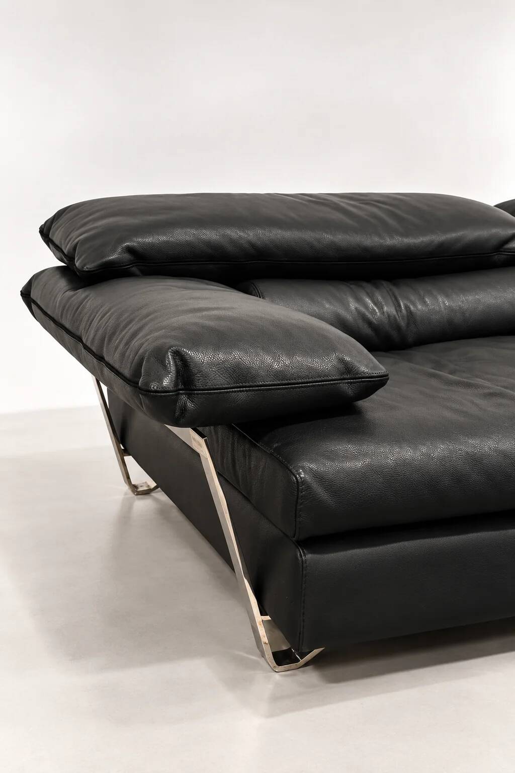Two-seater black leather sofa from Roche Bobois with a chrome frame.