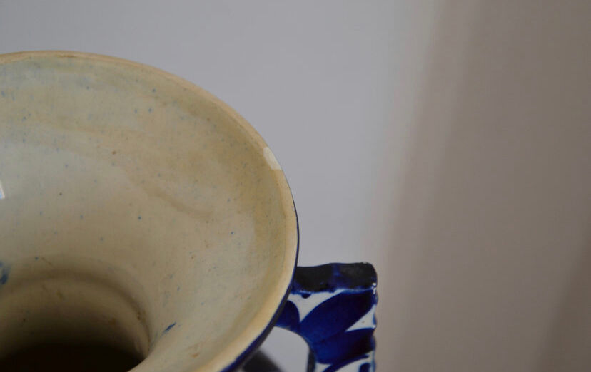 White hand-painted ceramic vase with blue patterns