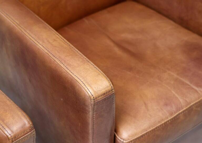 Pair of Art Deco armchairs in brown leather and teak, Netherlands, 1970s.