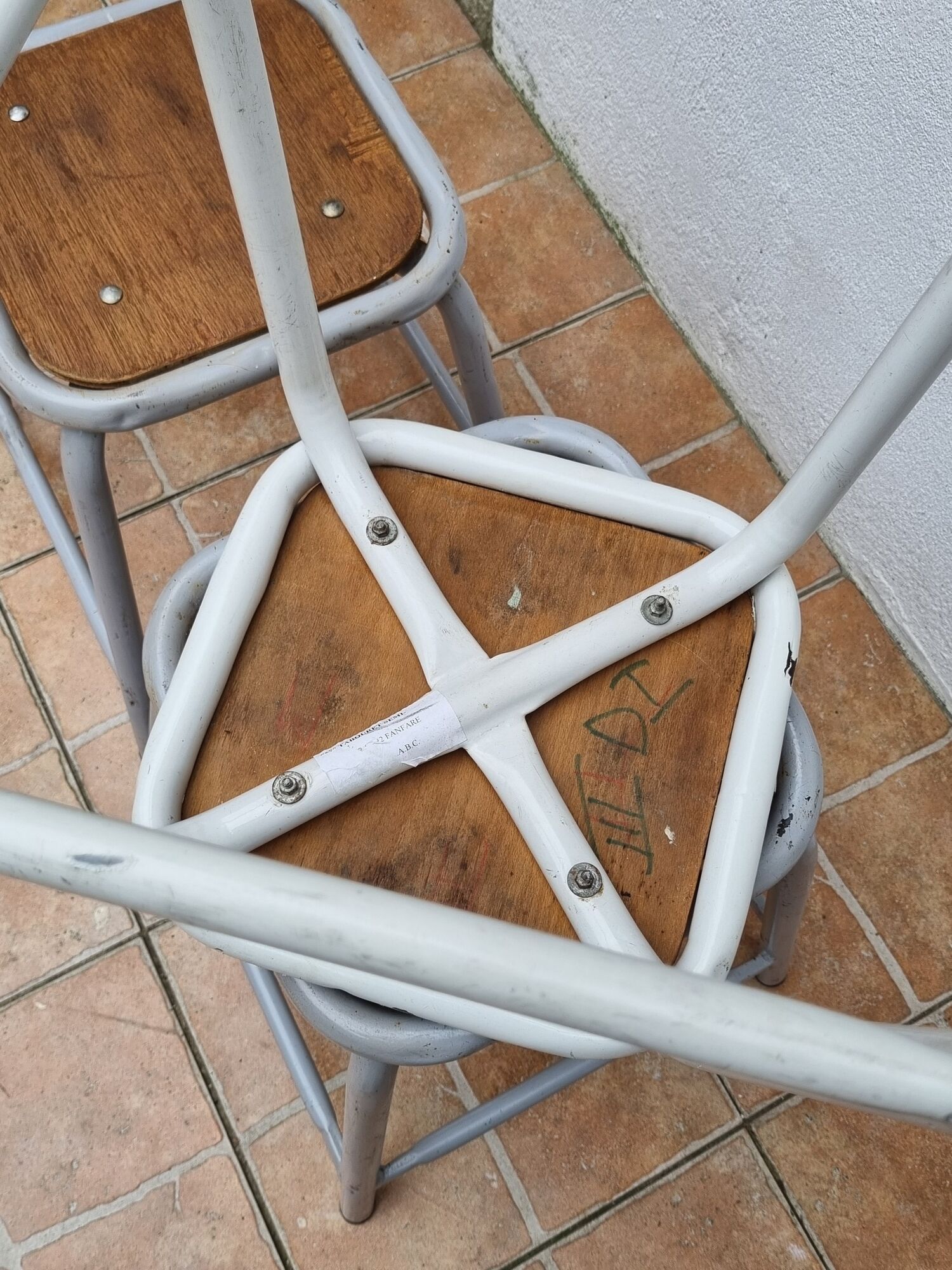 Set of four stackable industrial tubular metal and wood stools