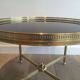Round coffee table in brass with a black lacquered glass top by Maison Jansen.