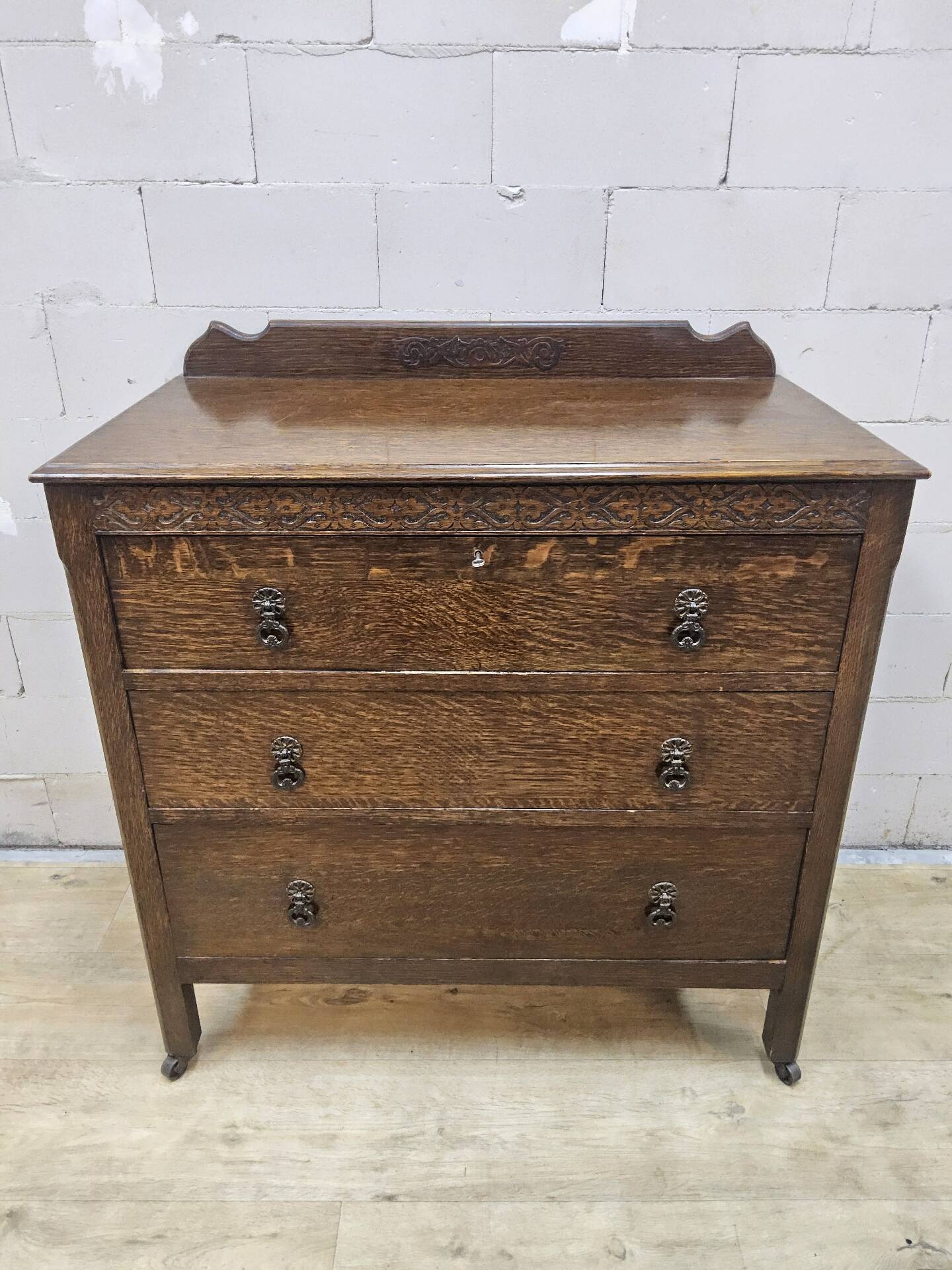 Antique chest of drawers on wheels with wood carving (key top drawer)