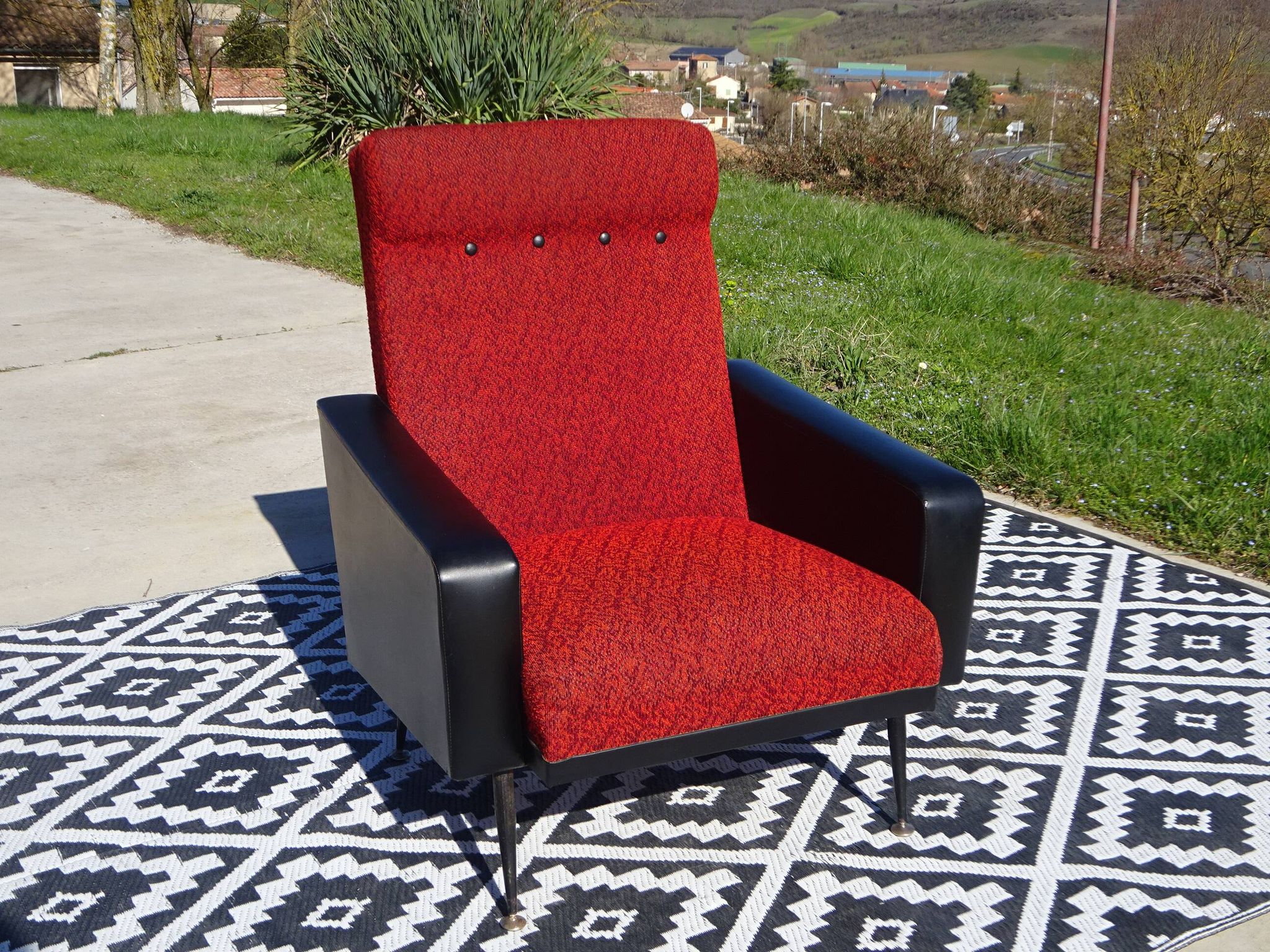Pair of vintage armchairs in black faux leather and red fabric.