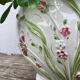 White ceramic pot cache of flower slip and old green foliage