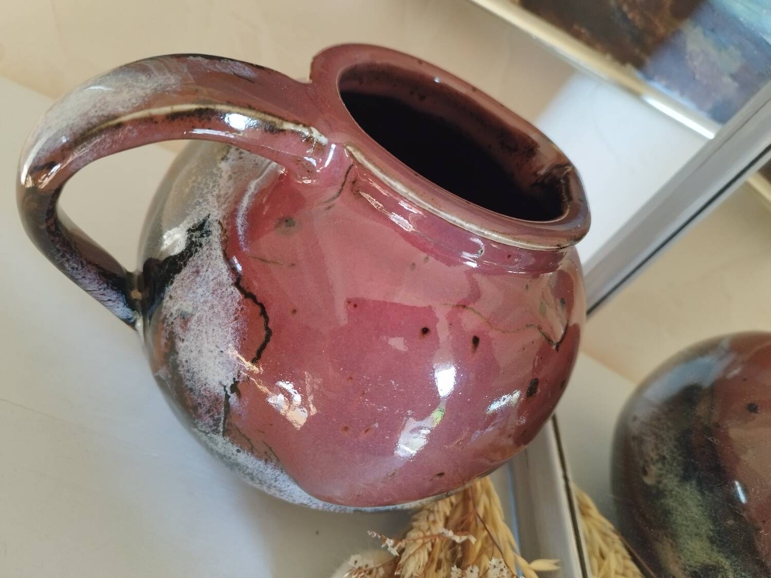 Stoneware pitcher by Matthieu Liévois in shades of red