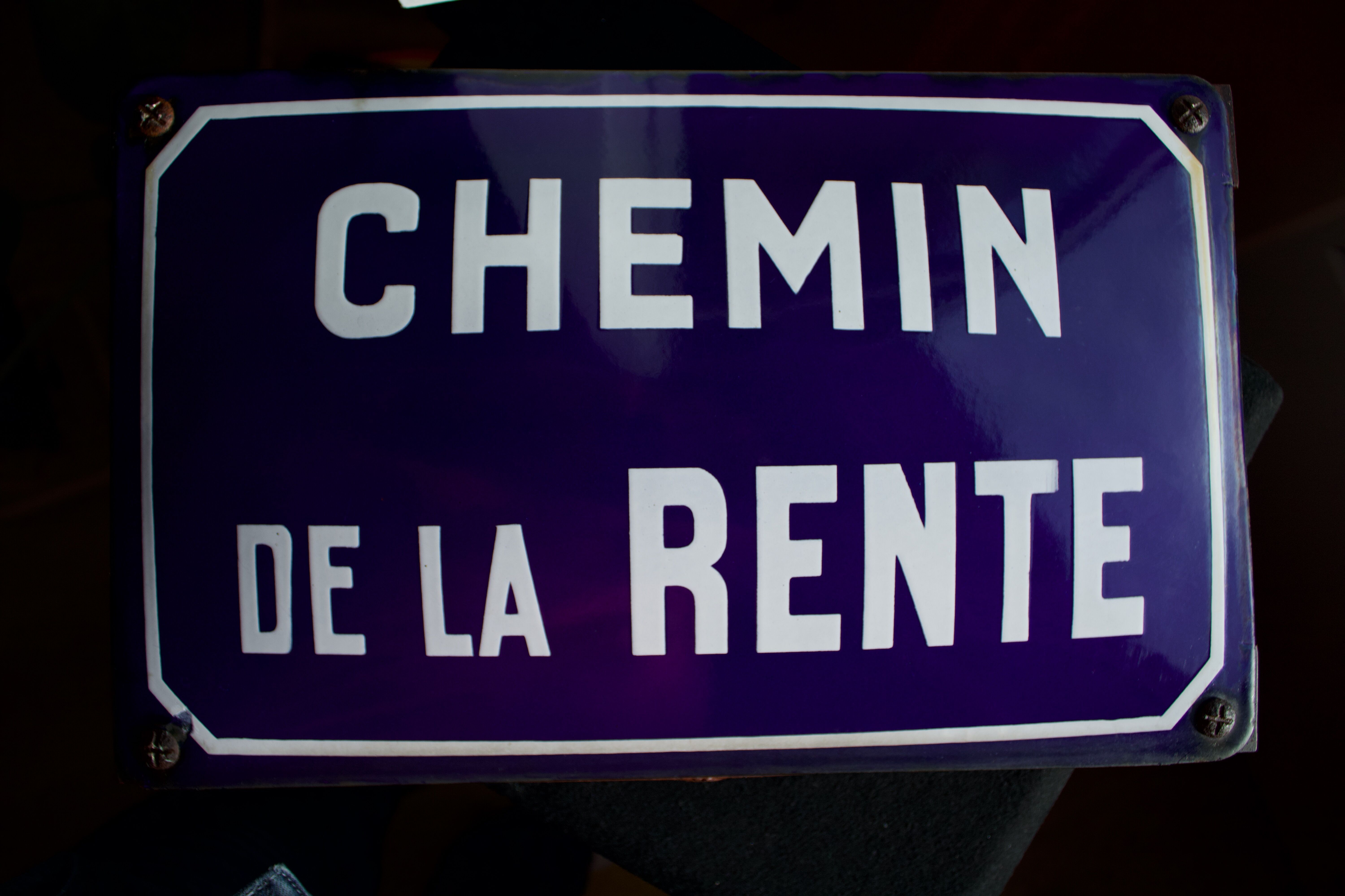 Old Enamelled and bulging "Chemin de la Rente" street plate, in perfect condition, on its cast iron support