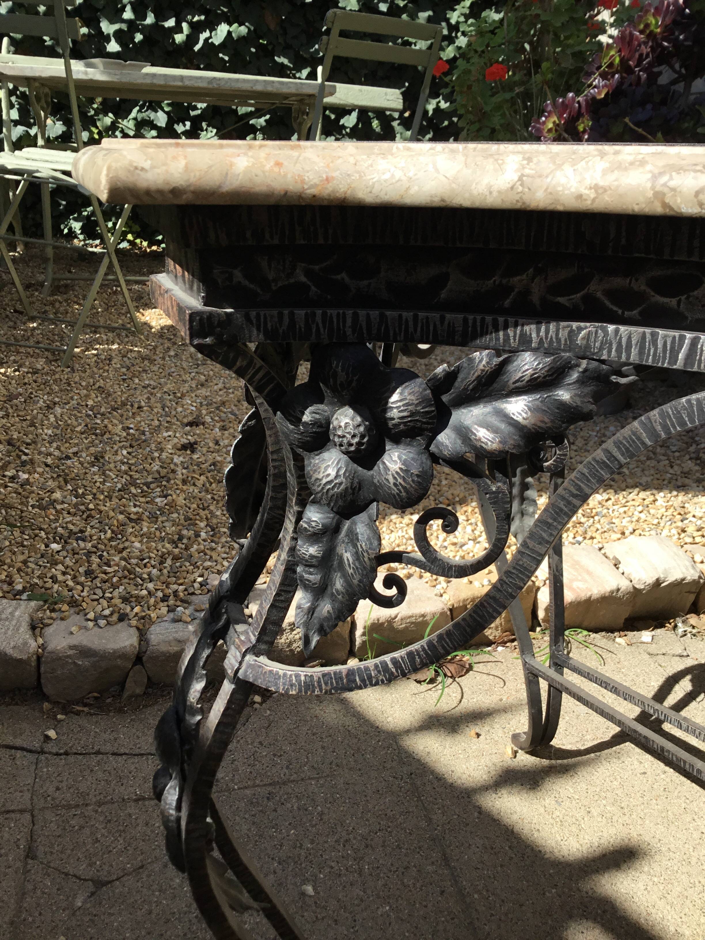 Table en fer forgé à ceinture ajourée de fleurs.plateau de marbre