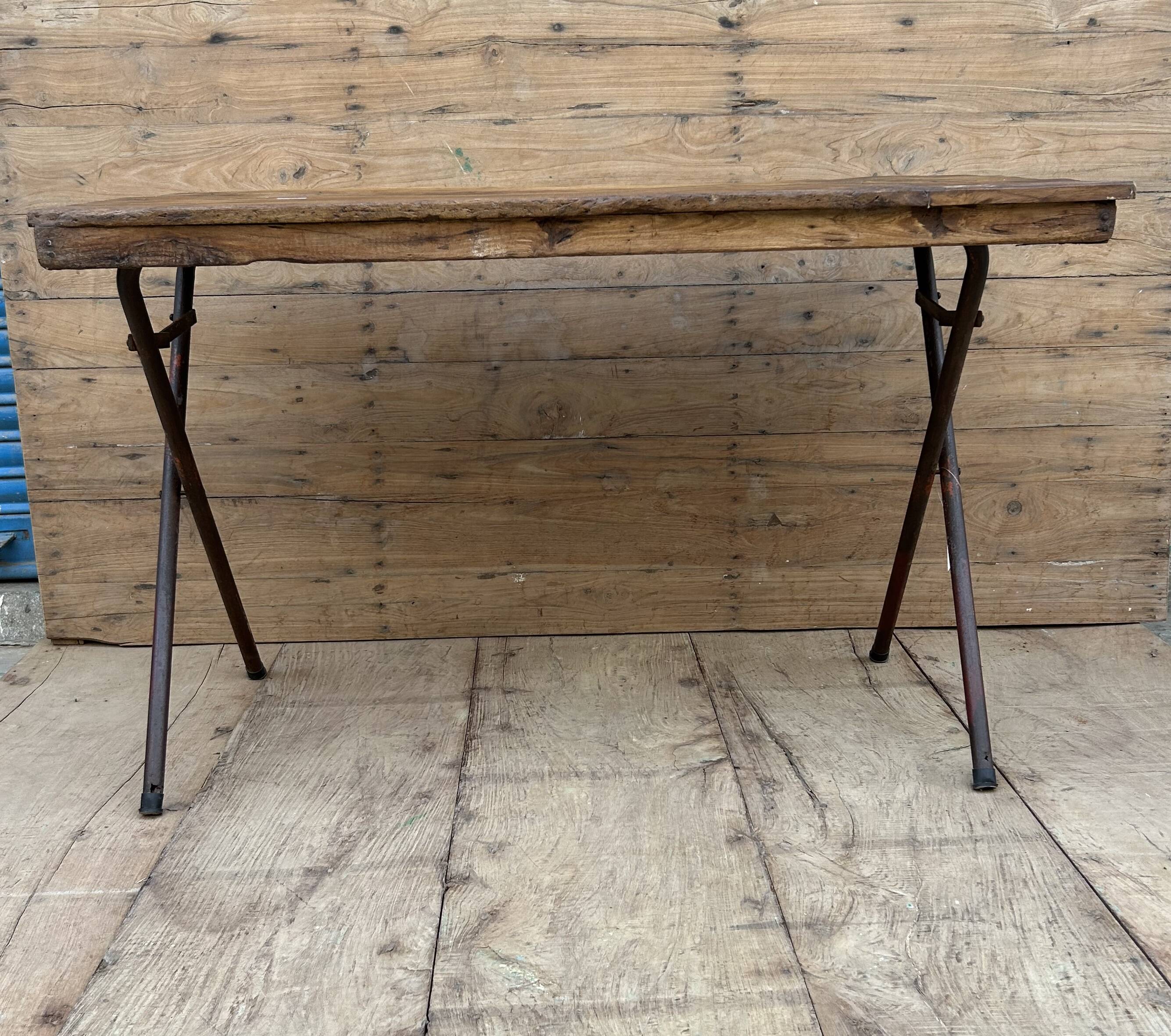 Folding workshop table with a metal frame and solid teak top.