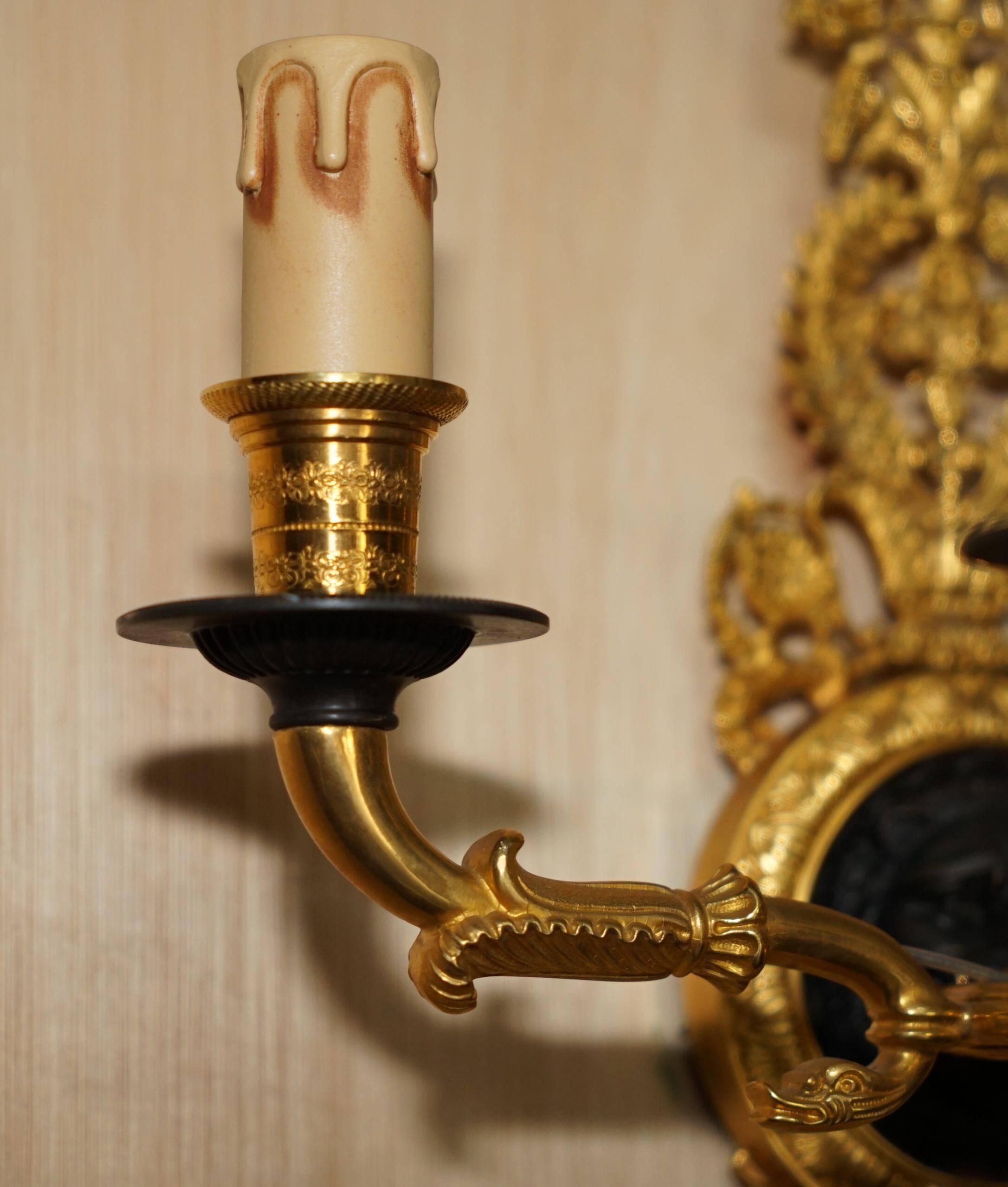 Pair of L'Originale wall sconces plated with 24-carat gold featuring four bronze candles.