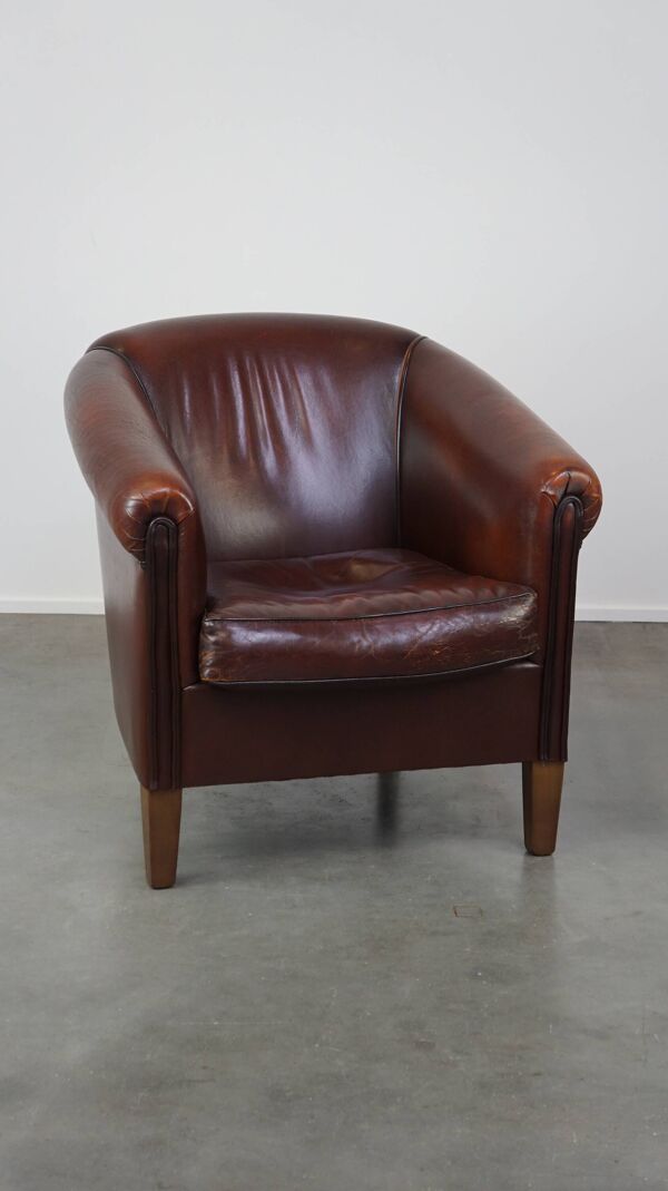 Joli fauteuil club en peau de mouton avec une belle patine