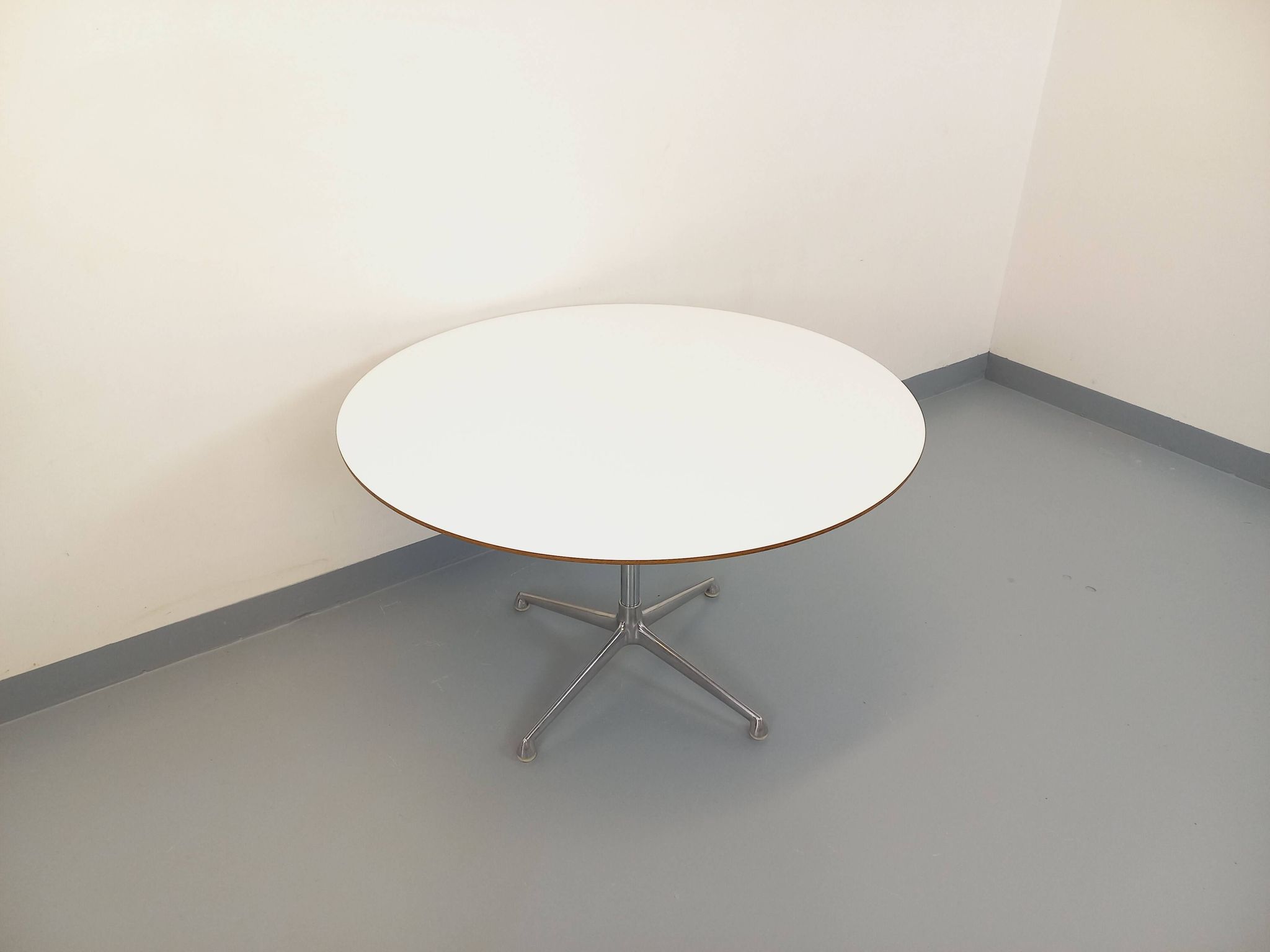 Vintage Eames round table for Vitra in white melamine, wood, and metal.