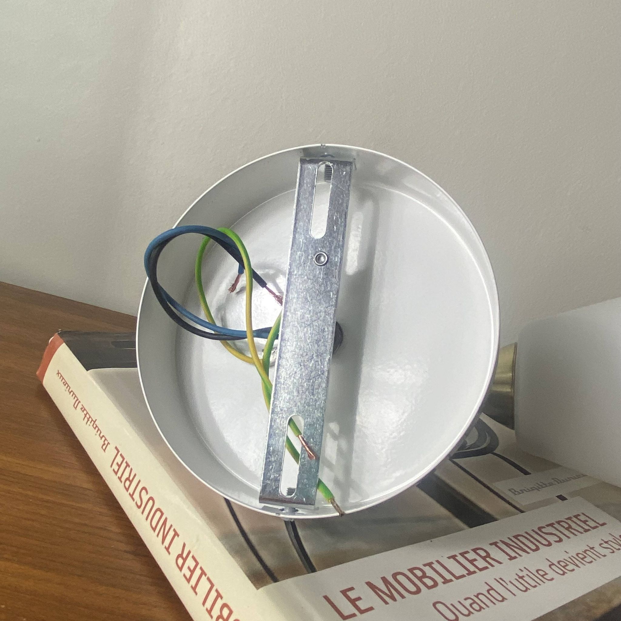 Swan neck wall light in brass with a white glass shade.