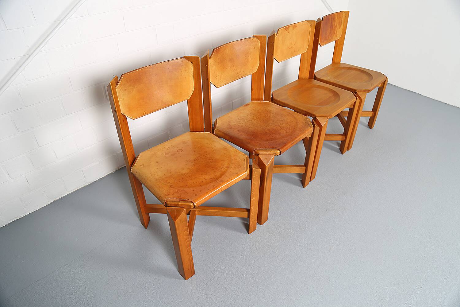 Set of 4 dining chairs in elm wood and cognac leather.