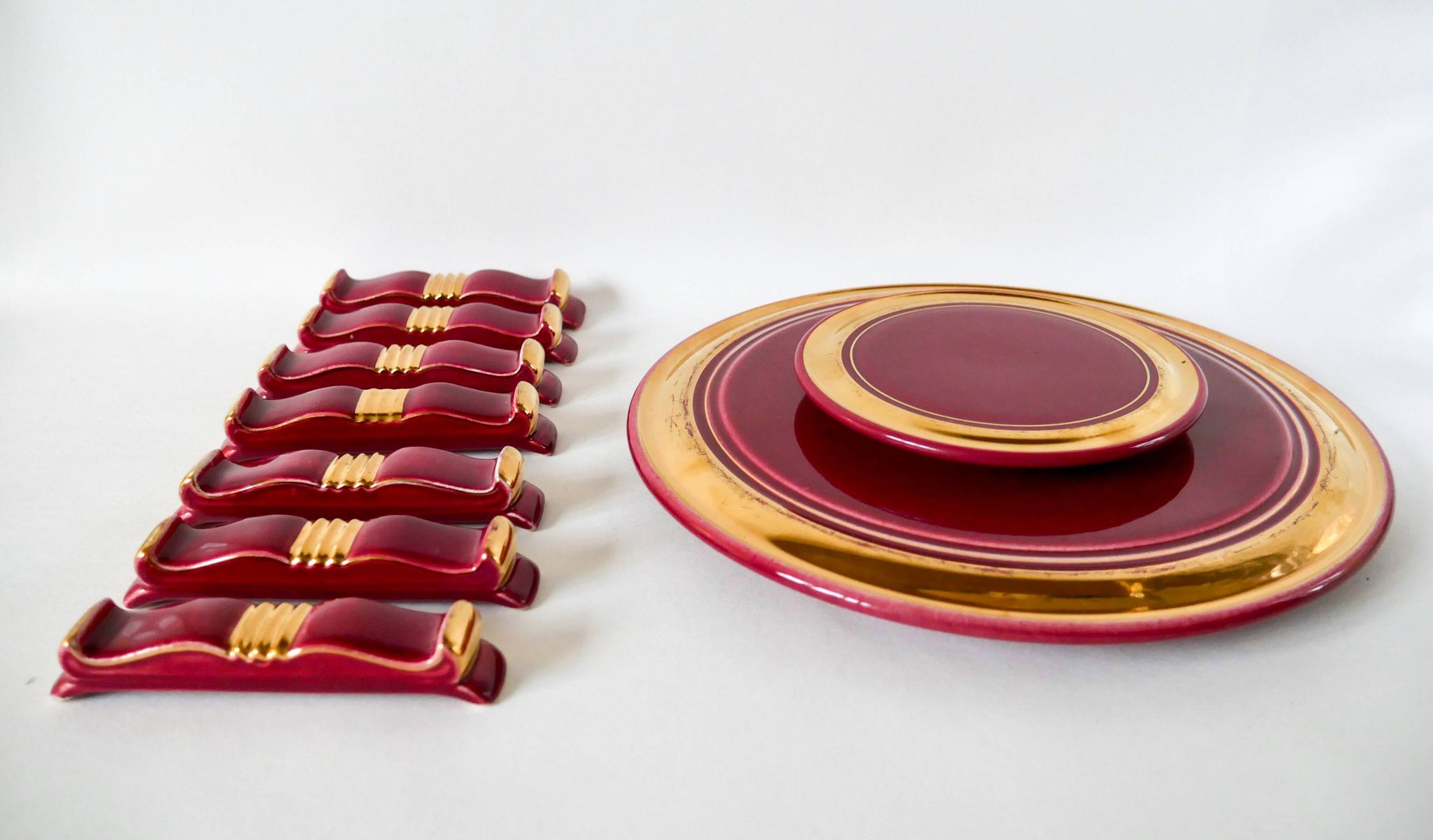 set of trivets, bottle coasters and knife holders in art de cherry-colored ceramic