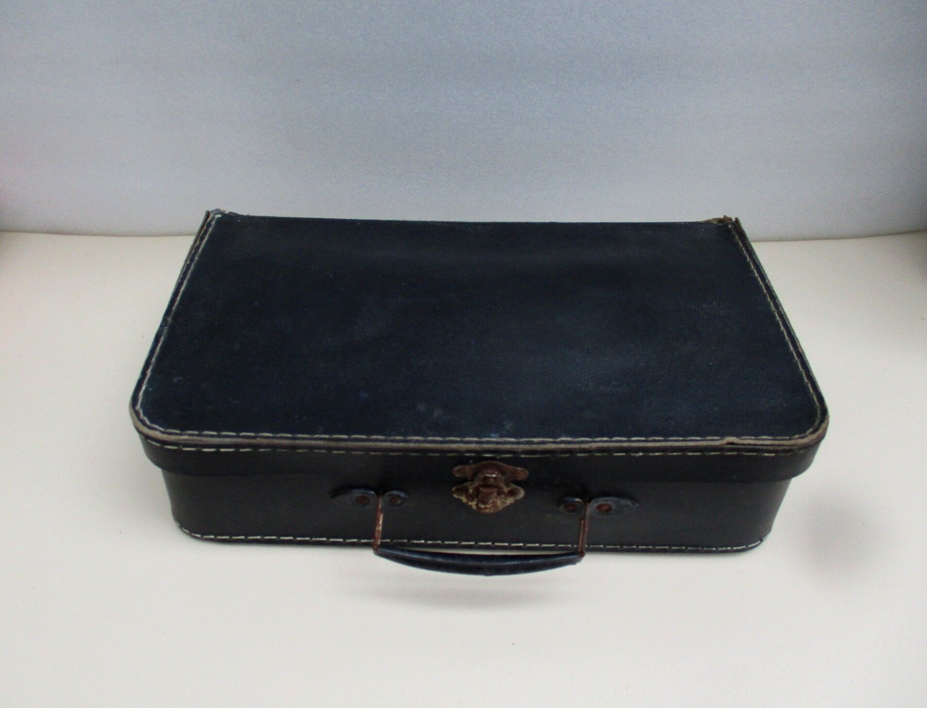 Small suitcase in old navy blue cardboard