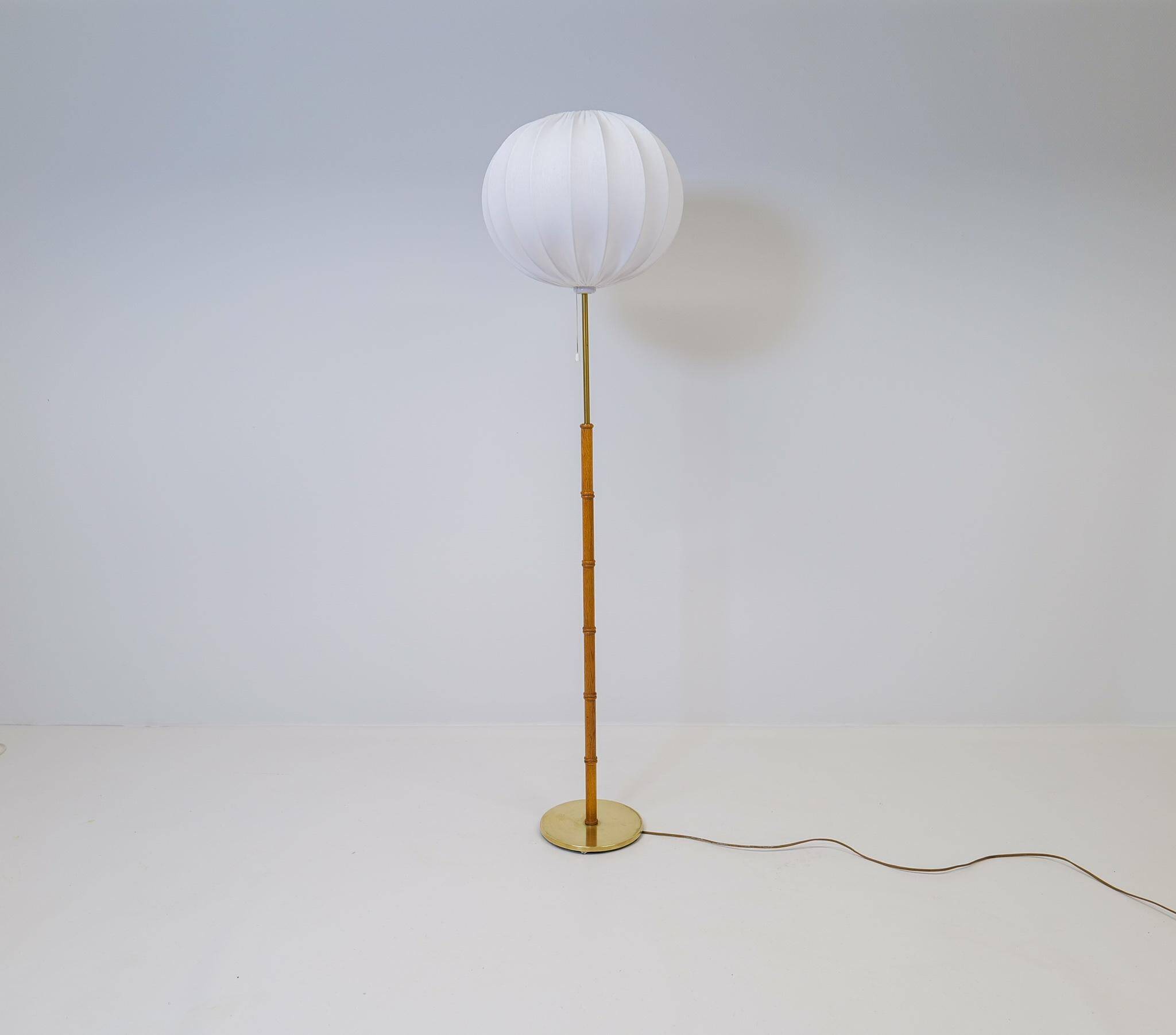 Mid-century floor lamp in brass and oak by Falkenbergs Belysning, Sweden, 1960s.