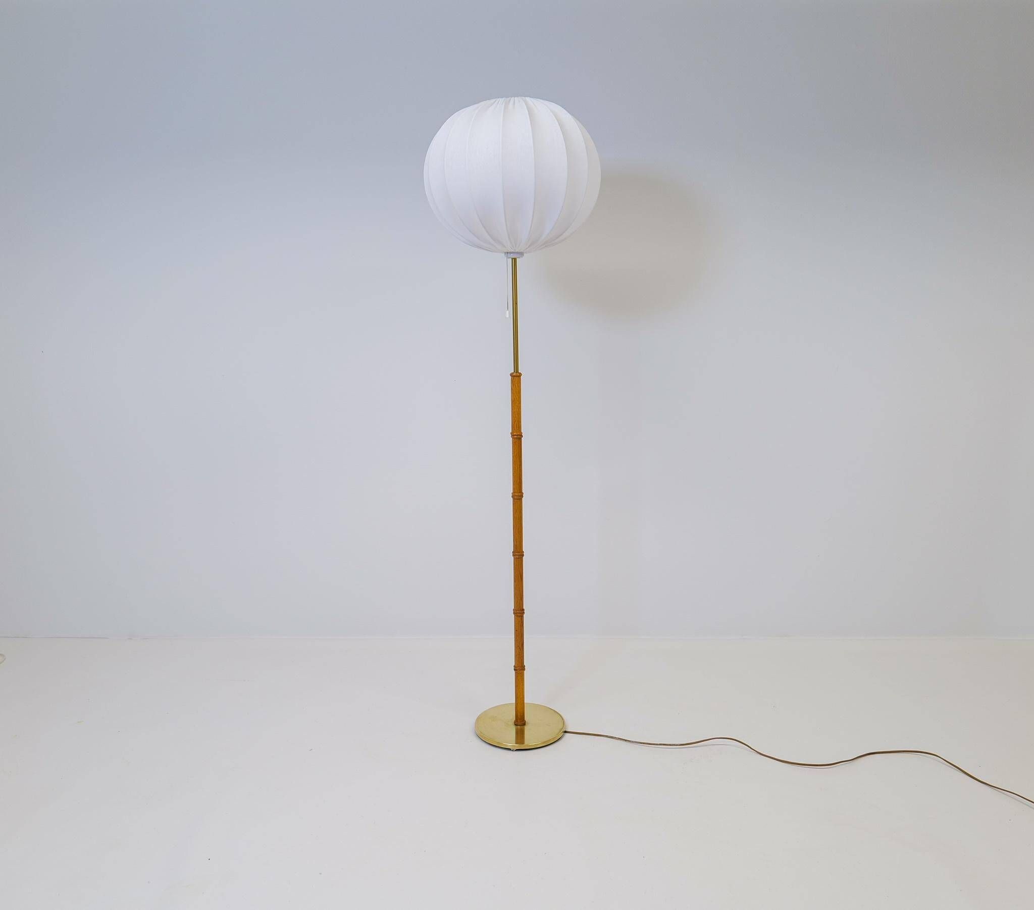 Mid-century floor lamp in brass and oak by Falkenbergs Belysning, Sweden, 1960s.