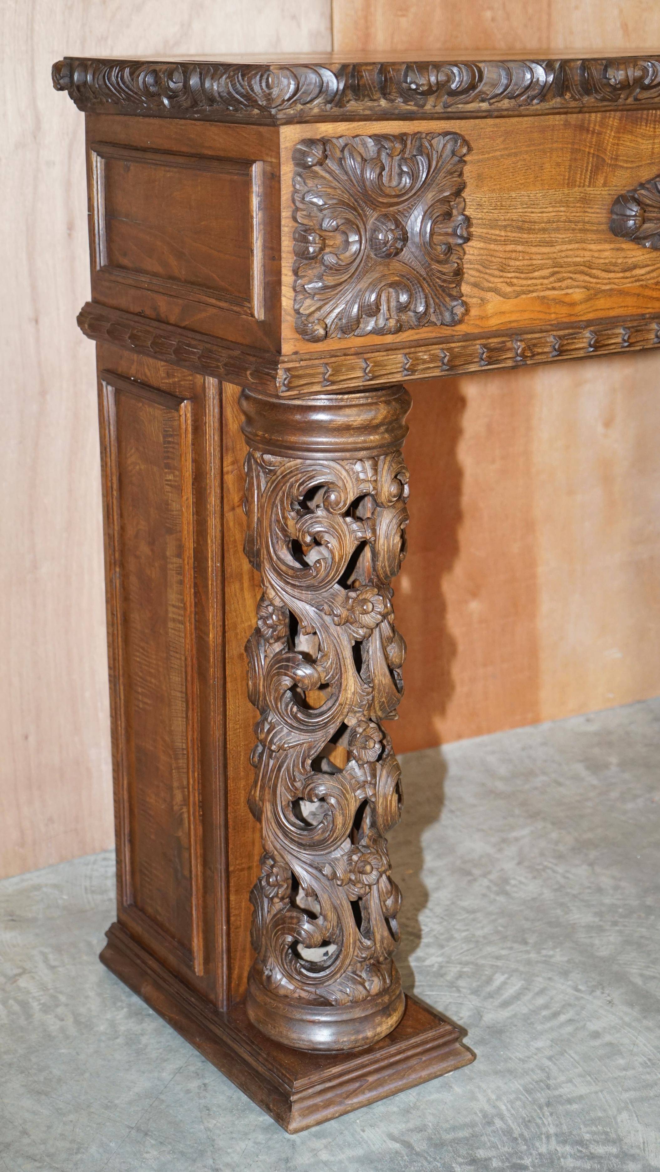Antique fireplace from around 1880 in solid hand-carved elm with openwork columns.