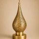 Handmade brass table lamp with a perforated drop-shaped shade.