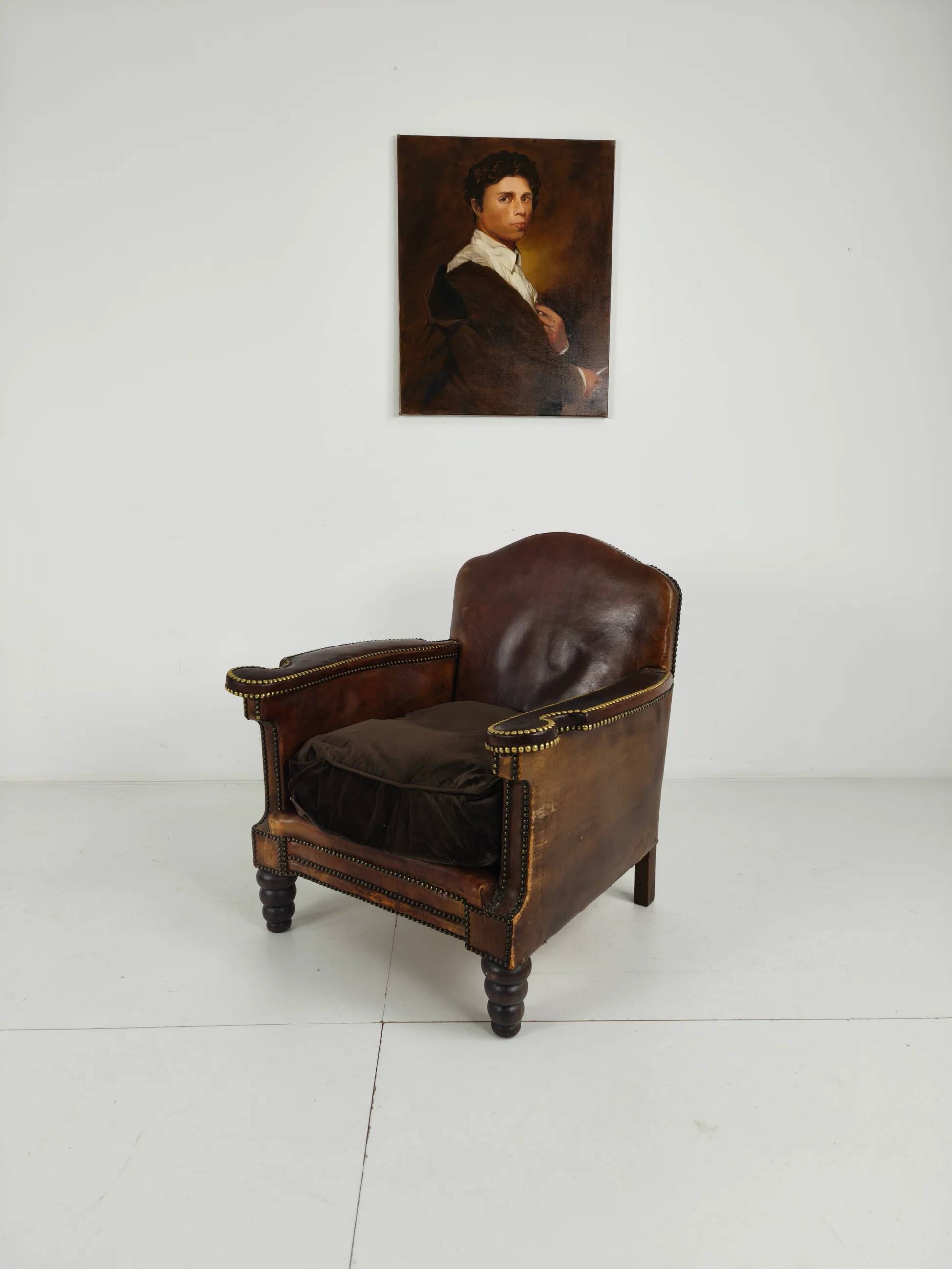 Antique leather club chair with stud detailing