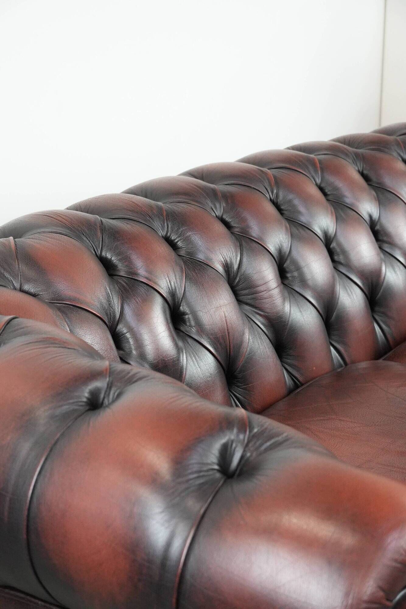 Classic cowhide Chesterfield sofa in English style with red/brown colours