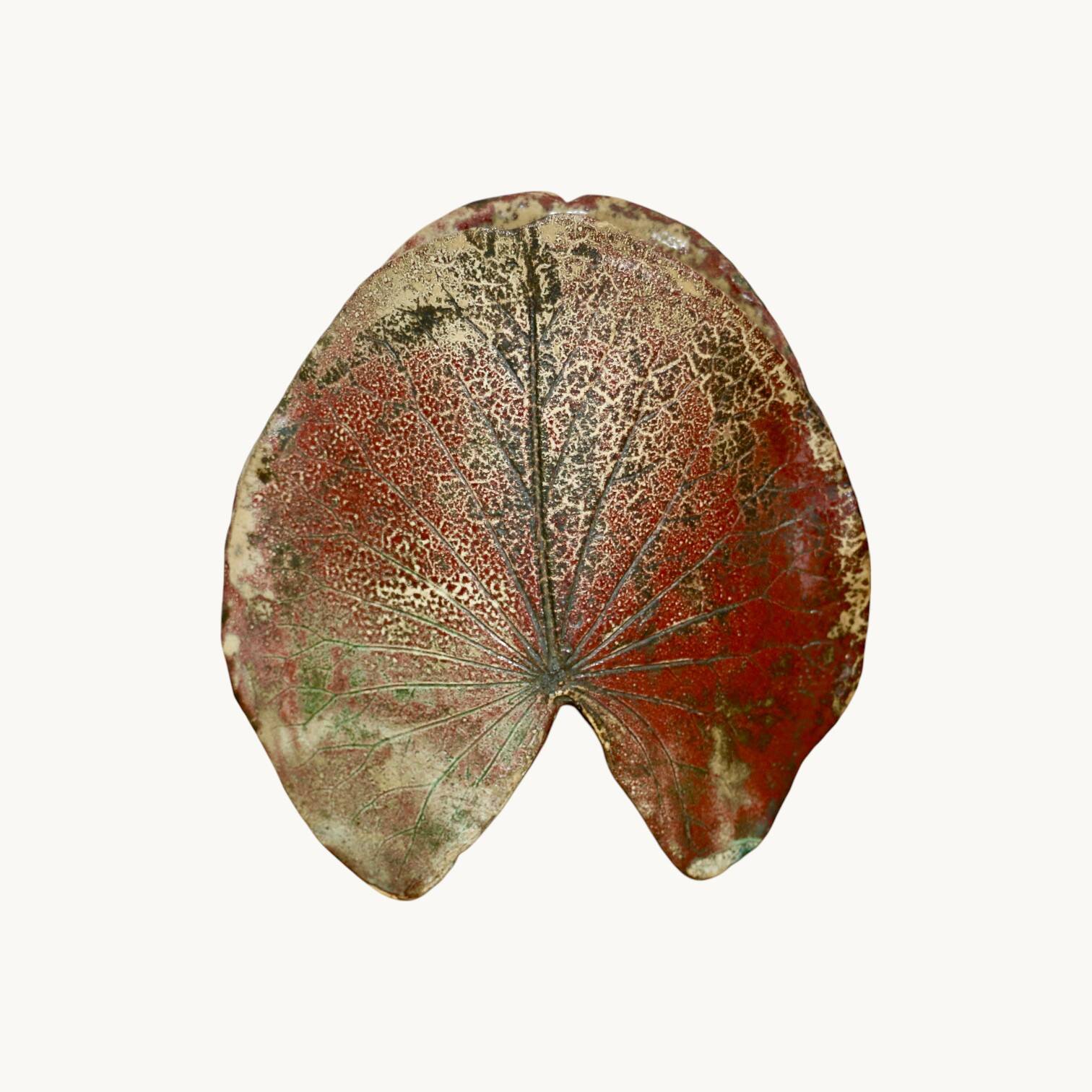 A ceramic lamp in the shape of a leaf.