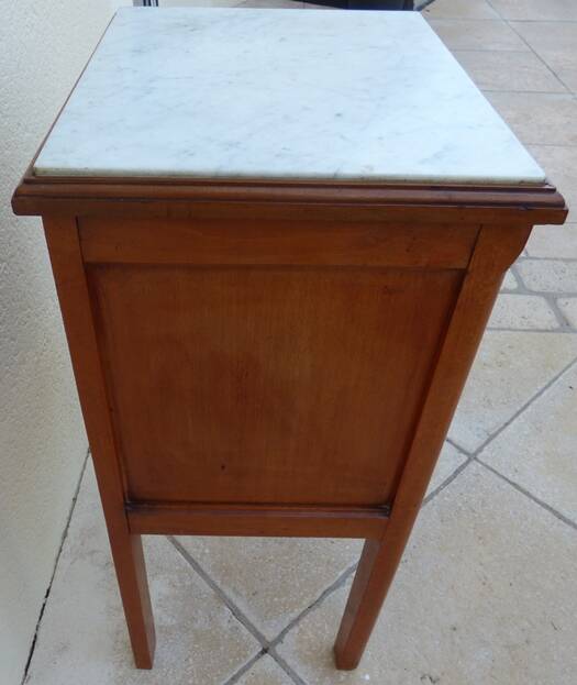 Antique bedside table with its marble top and white earthenware interior