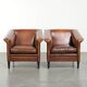 Ensemble de deux fauteuils en peau de mouton au design Art Déco avec passepoil noir.