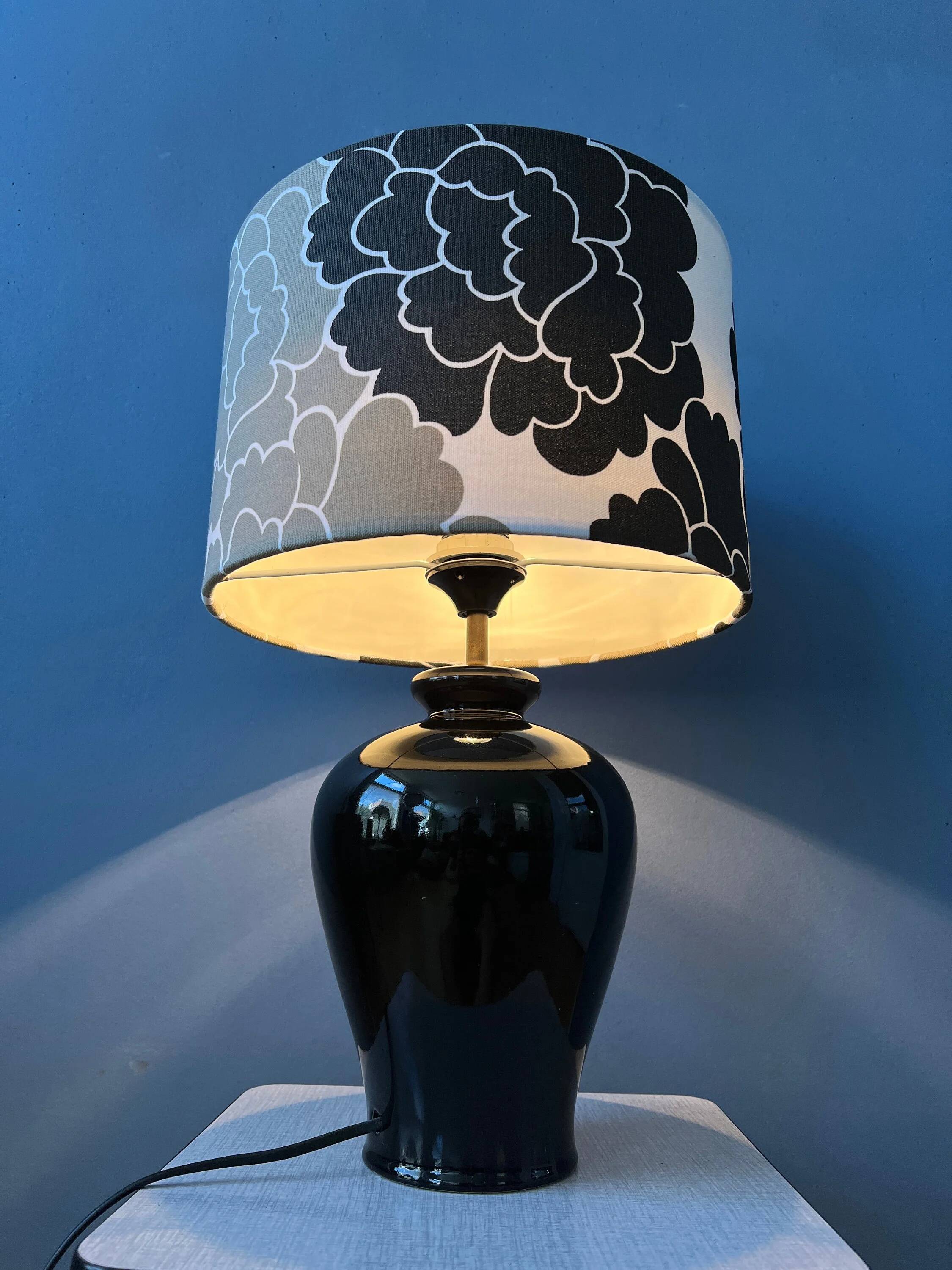 Small Space Age table lamp with a porcelain base and black and white flower shade.