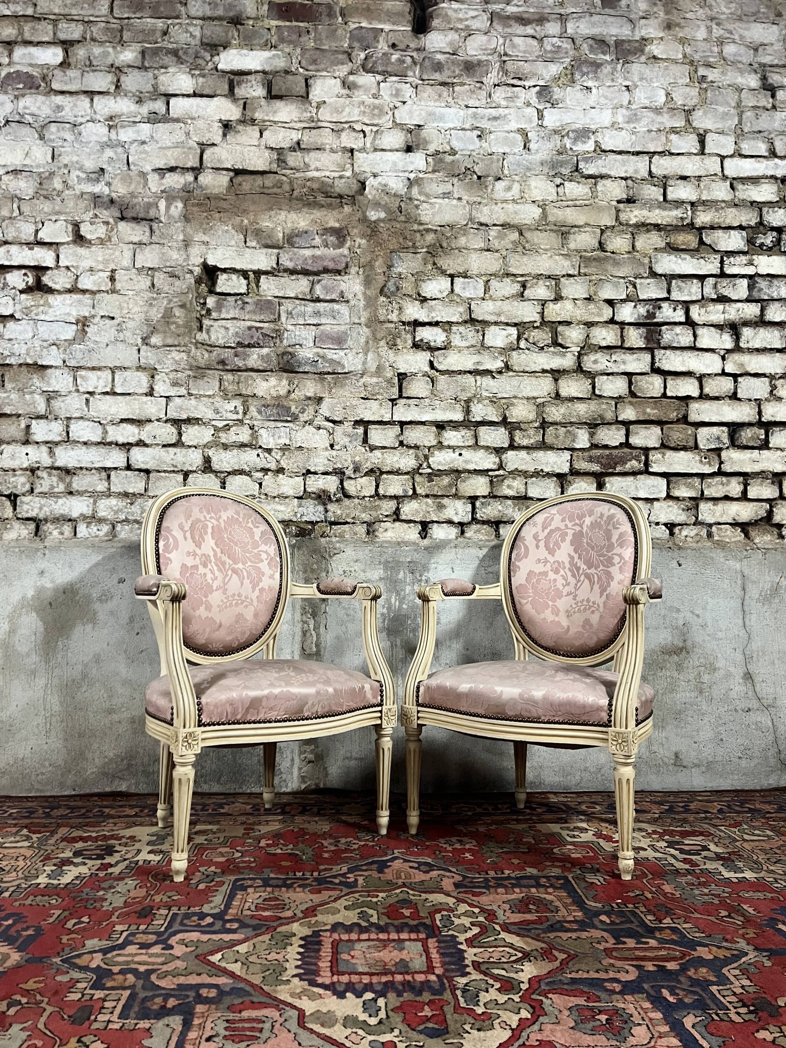 Paire de fauteuils dossier médaillon en bois laqué crème de style louis xvi