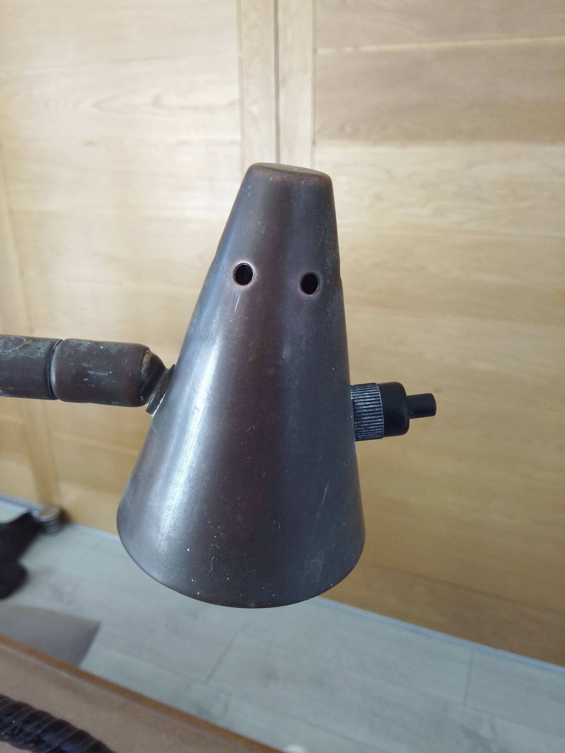 Old desk lamp with a small copper shade and a porcelain base.