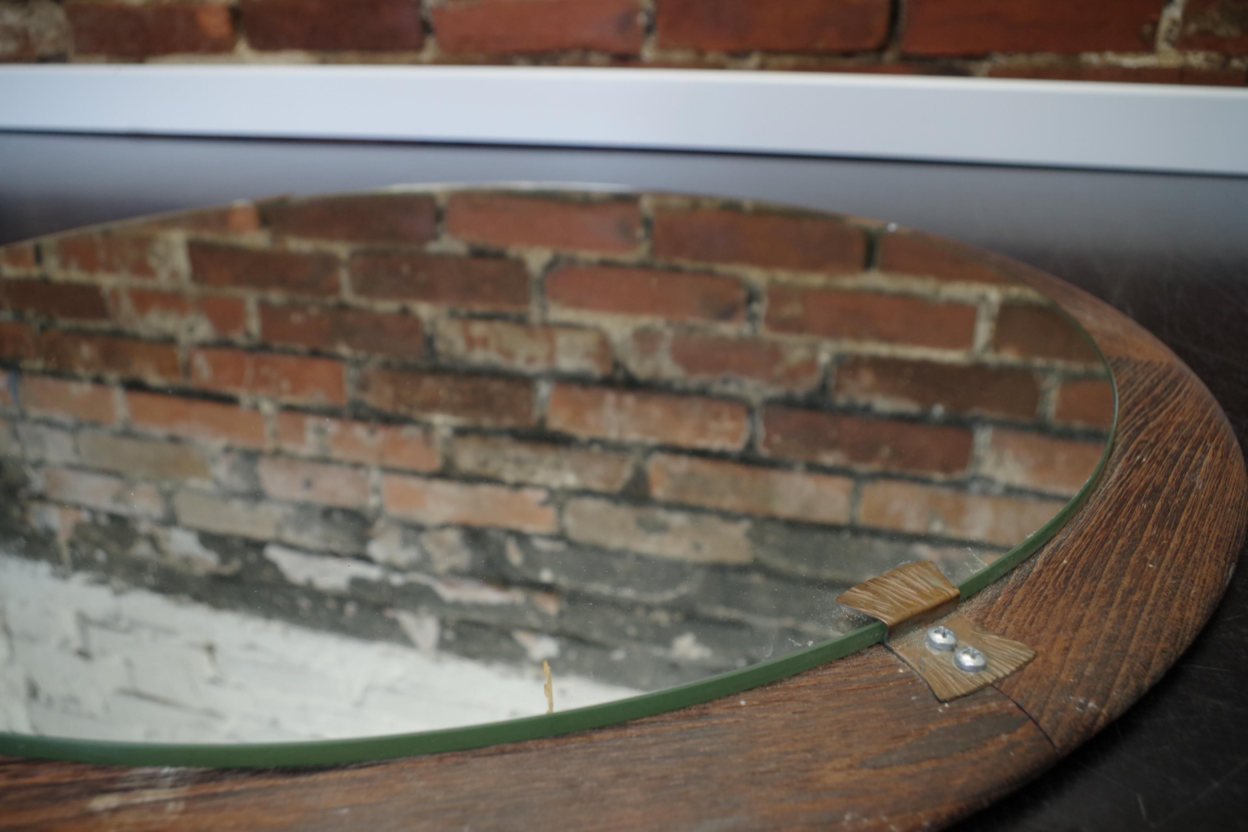 Round mirror in a vintage teak wood frame