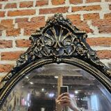 Ancien miroir ovale patiné noir et doré style louis xv