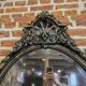 Old black and gold patinated oval mirror louis xv style