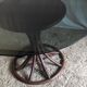 Round dining table tulip foot in rattan and smoked glass 70s