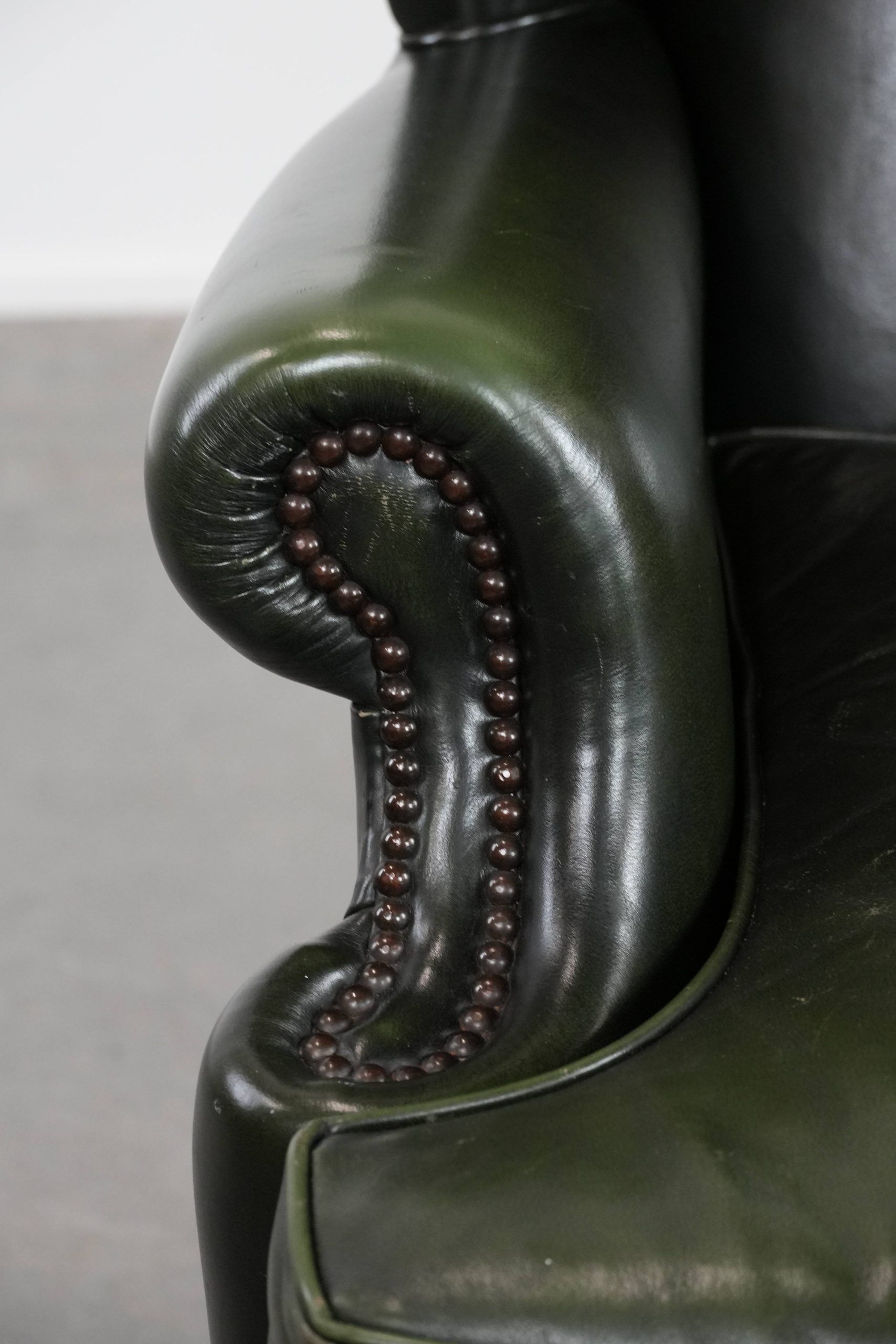 Smooth classic cowhide Chesterfield armchair in a stylish dark green color