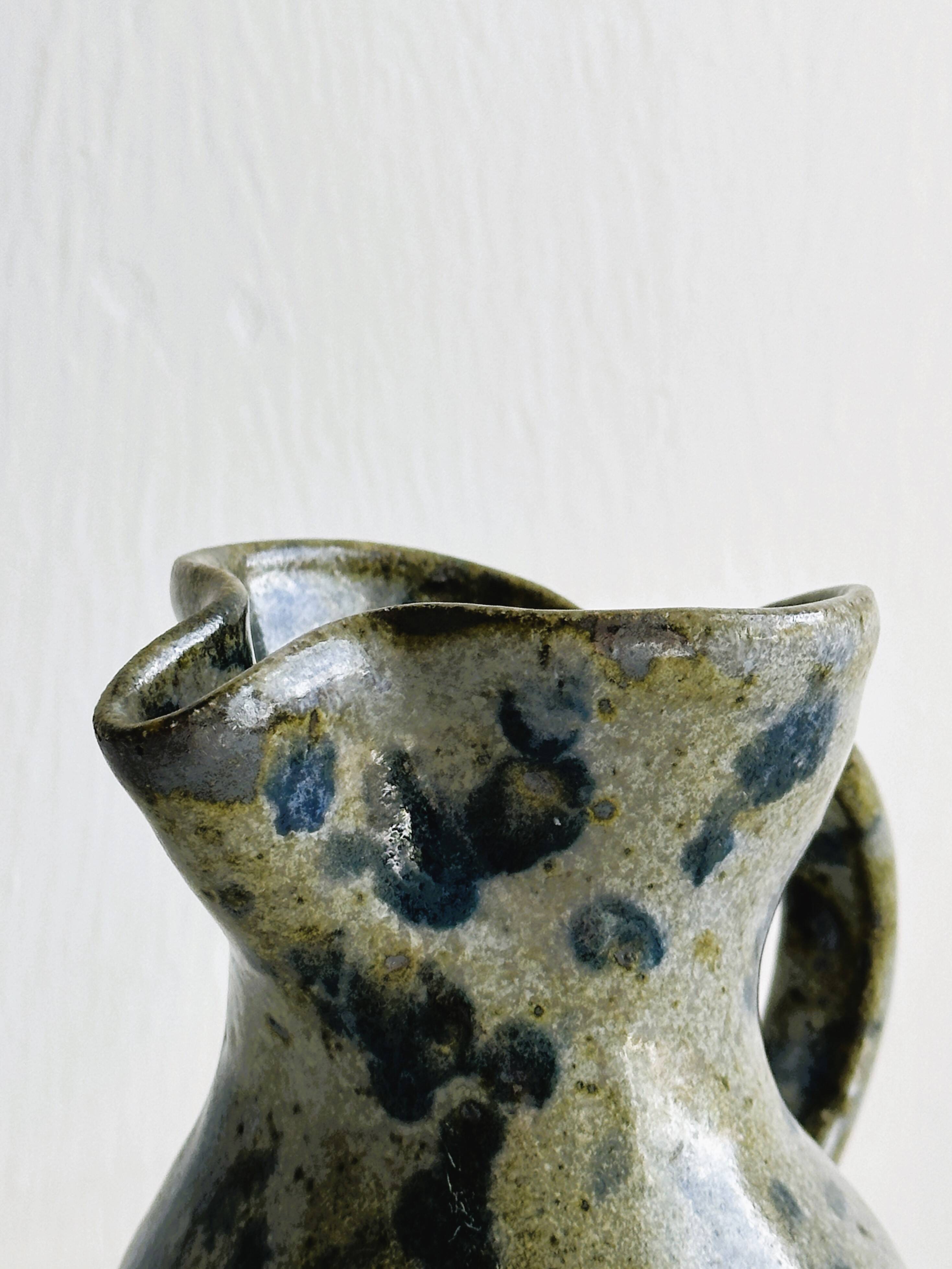 Small handcrafted ceramic pitcher with spotted enamel