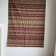 Large Indian rug with red, yellow, and white stripes and geometric fringes.