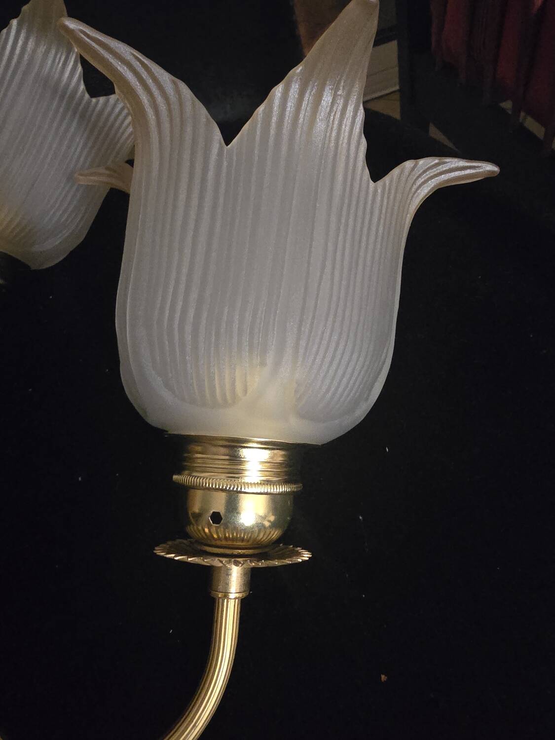 Frosted glass wall sconces and gilded brass in Art Deco style.