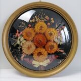 Dried flowers under curved glass frame