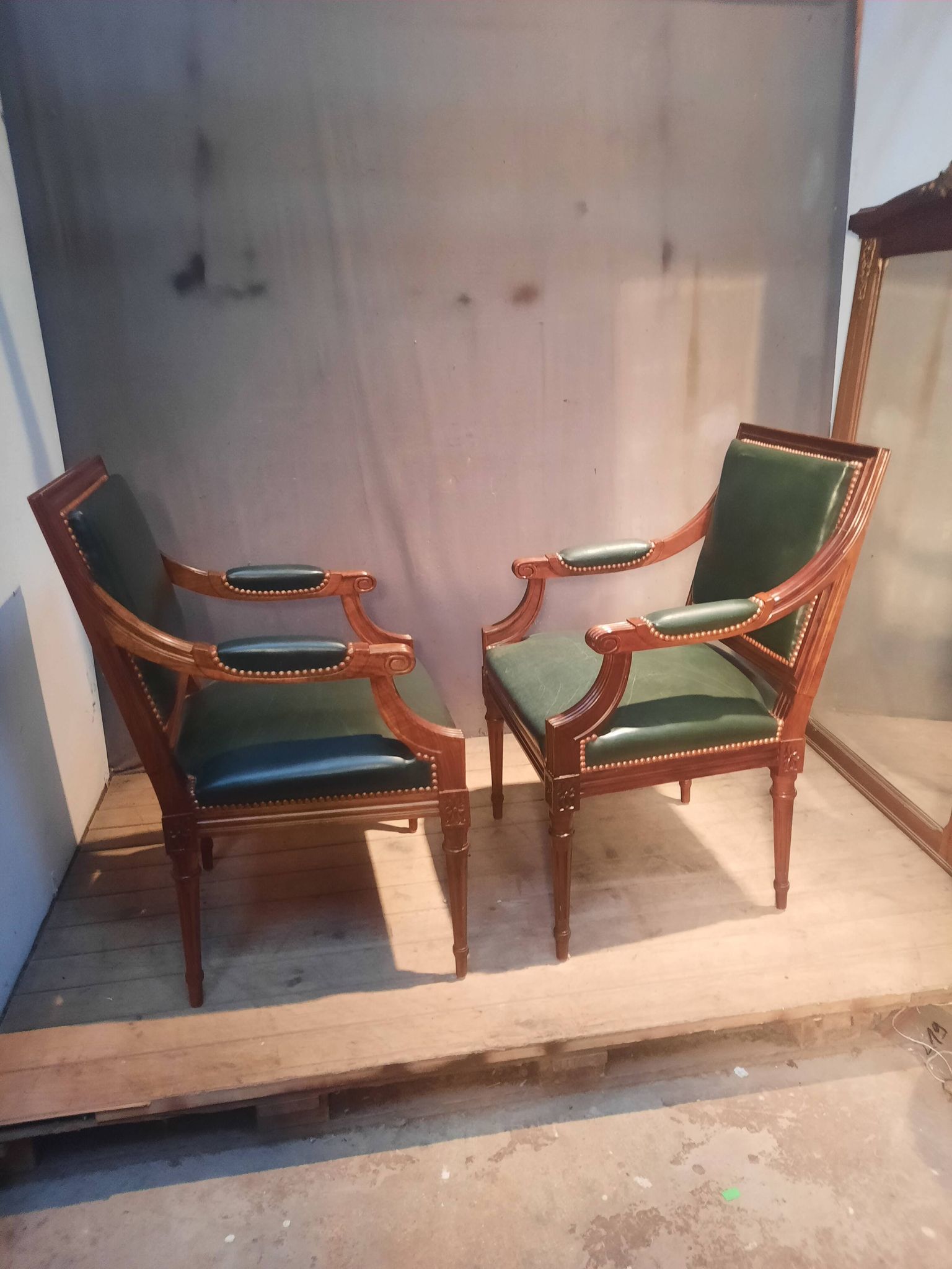 Pair of Louis XVI style armchairs upholstered in green leather.